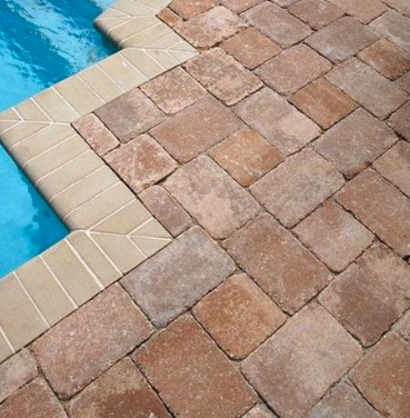Newly laid and sealed pavers around a pool.
